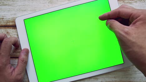 hombre usando tableta digital con pantalla verde llave de croma en la mesa de la chica en mal estado.
