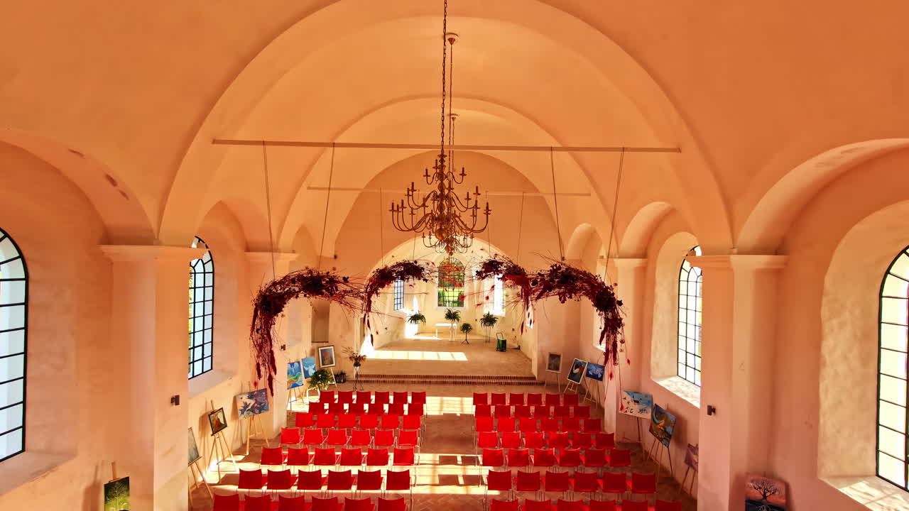 Interior view of Mežotnes baznīca kultūrtelpa church with red chairs during daytime in Latvia