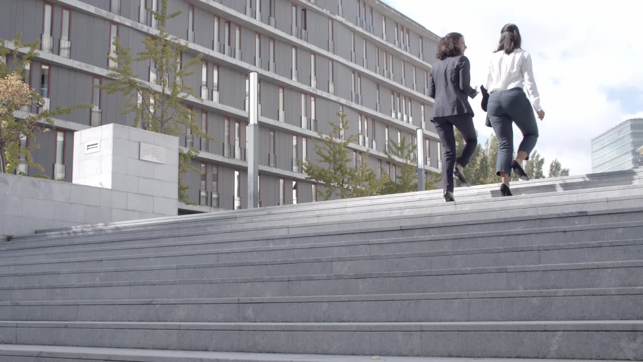 dos mujeres de negocios exitosas subiendo las escaleras