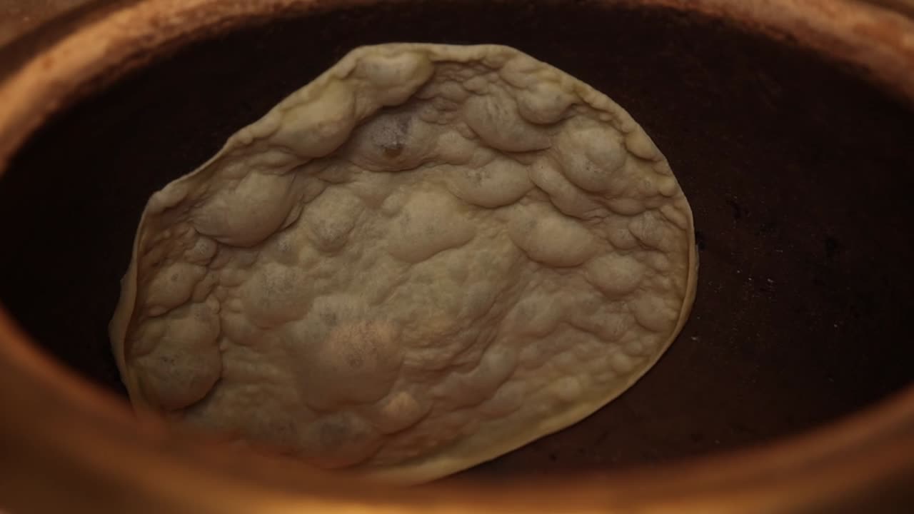 Cottura di pane azzimo in un forno tandoor