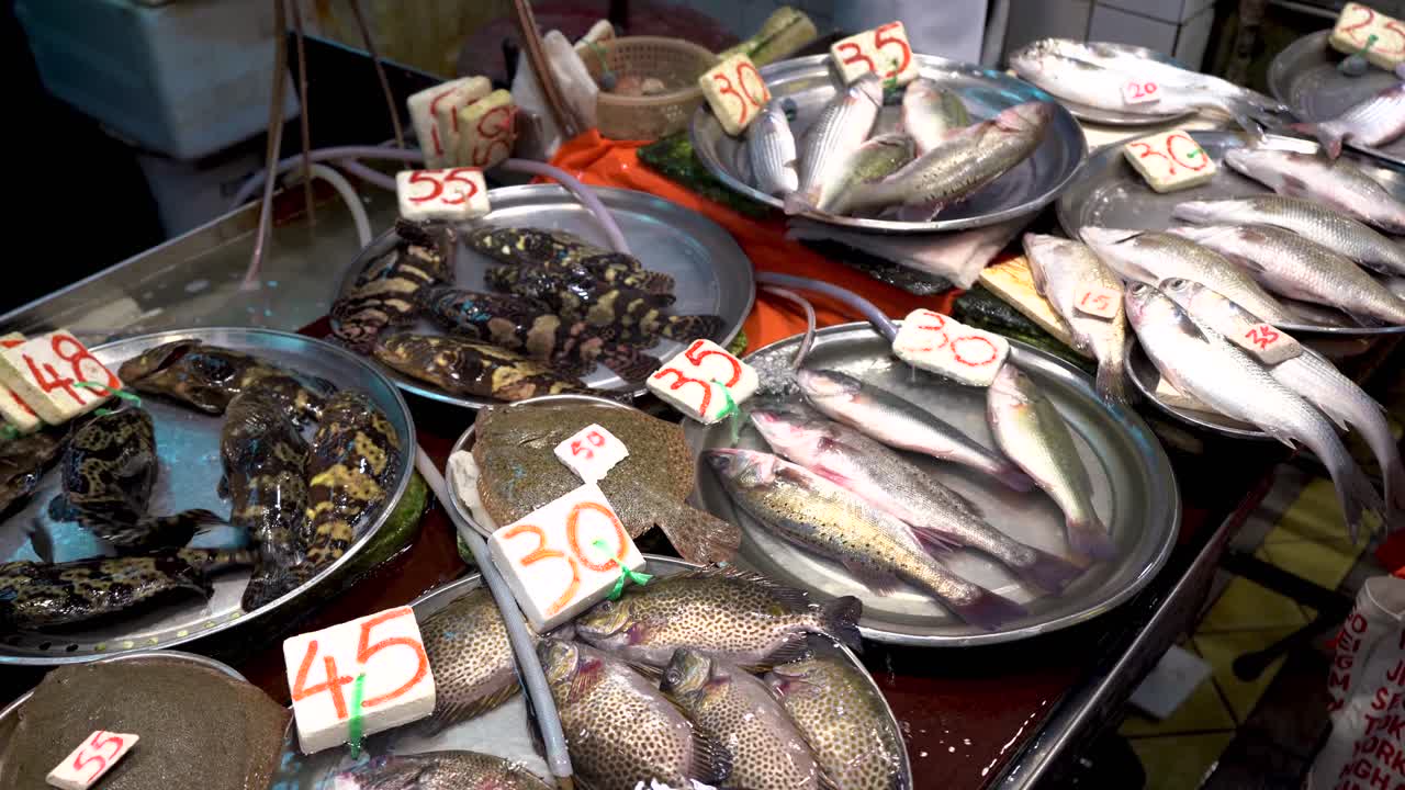 홍콩 습식 어시장에서 판매되는 가격표가 있는 다양한 활어