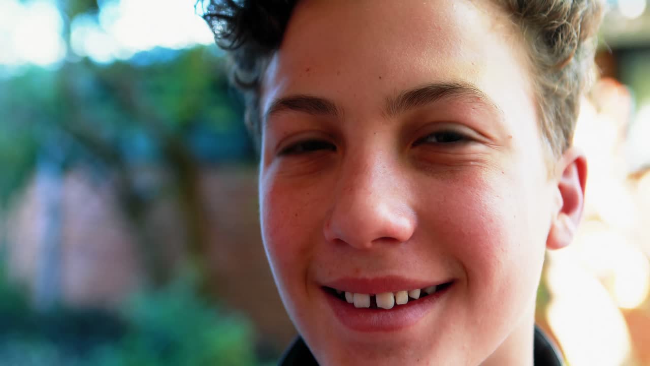 Estudante sorridente em pé com a mochila no campus
