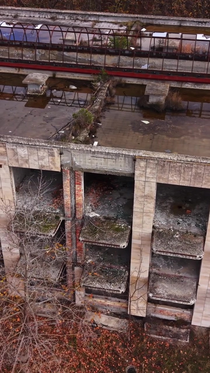 Edificio industrial abandonado con charcos de agua en los tejados en otoño