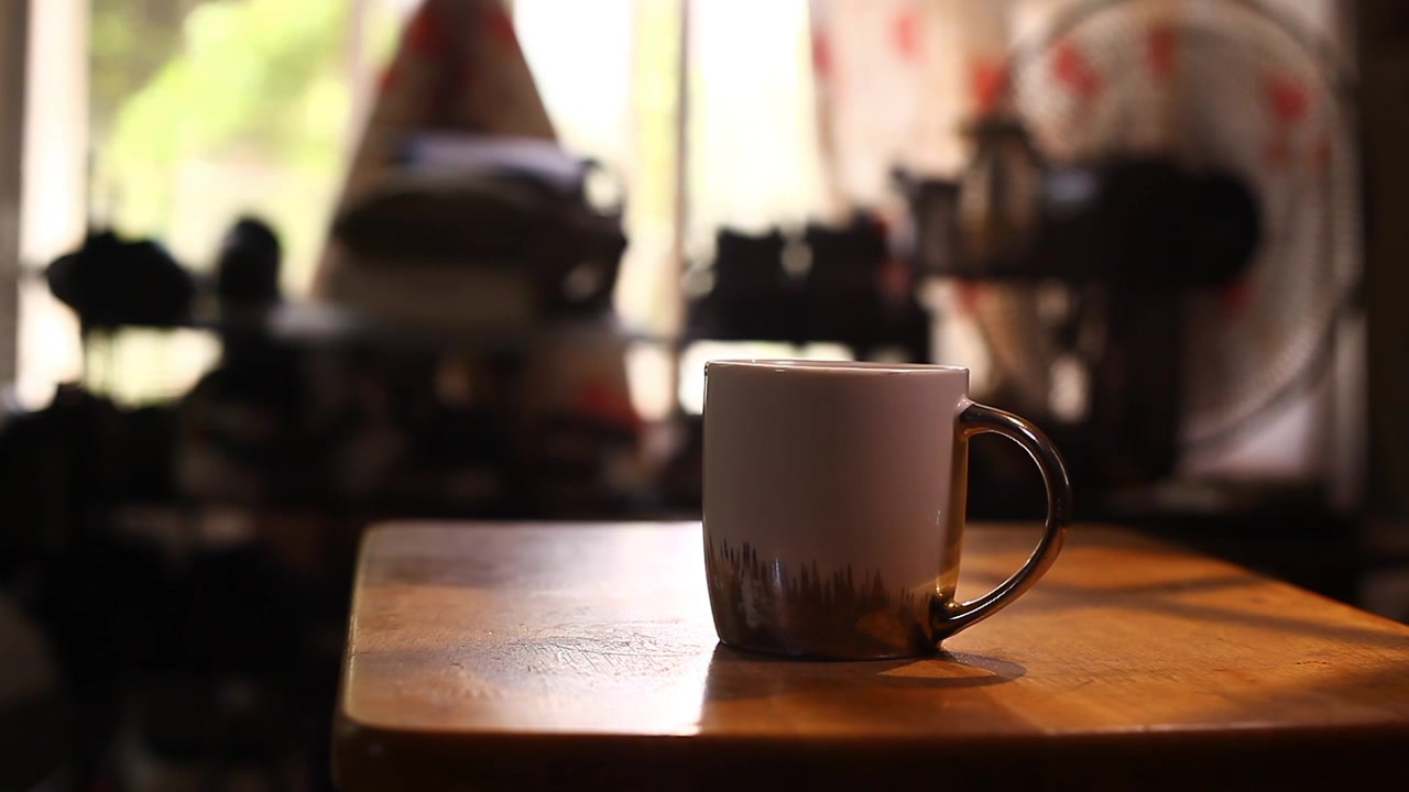 Tazza di caffè e cibo filippino chiamato Pandesal posizionati su un tavolino.