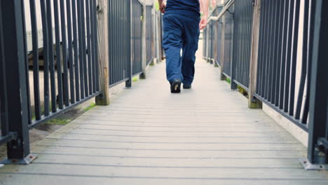 piernas de un hombre caminando por la rampa con pasamanos al aire libre