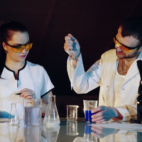 Young scientists conducting tests or research in the laboratory. Lab technician checks the test tubes. Square video