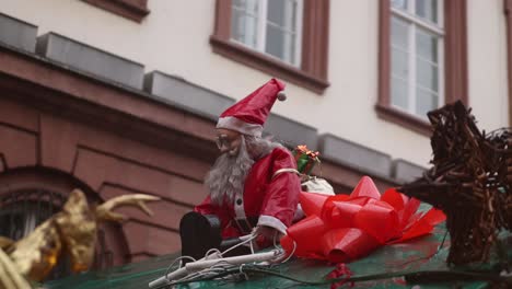 santa-clause-decoration-with-a-bow-on-top-of-a-shop-in-Heidelberg,-germany-at-a-Festive-Christmas-market-in-Europe
