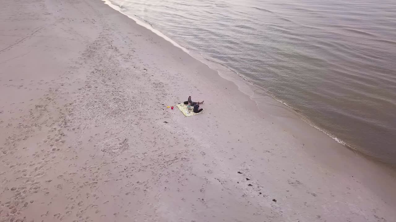 Happy Family Enjoying a Day at the Beach. Drone Footage of a Family on Beach. Family Vacation 60 fps aerial shot.