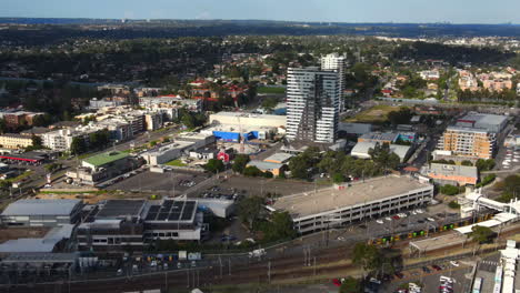toma aérea de las carreteras australianas en un suburbio con mucho tráfico ferroviario y automóviles y negocios - blacktown nsw