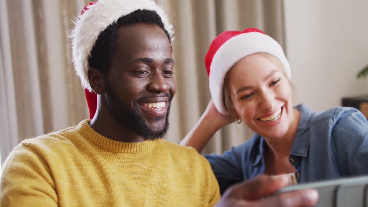 grupo feliz de amigos diversos que usan teléfonos inteligentes para videollamadas en una fiesta de navidad