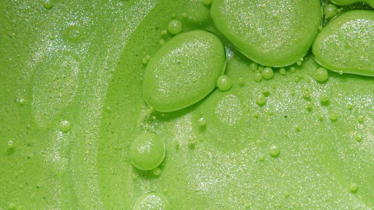 밝은 녹색 거품이 반이고 있습니다.