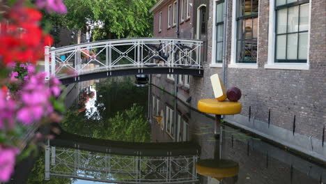 small bridge with reflection over canal in lange tiendeweg, gouda, south holand, netherlands