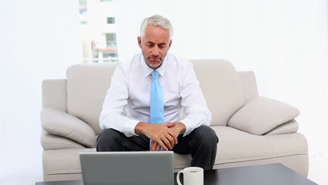 hombre de negocios estresado mirando la computadora portátil y luego la cámara