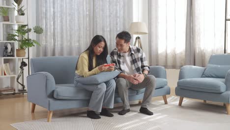 couple using smartphone on couch