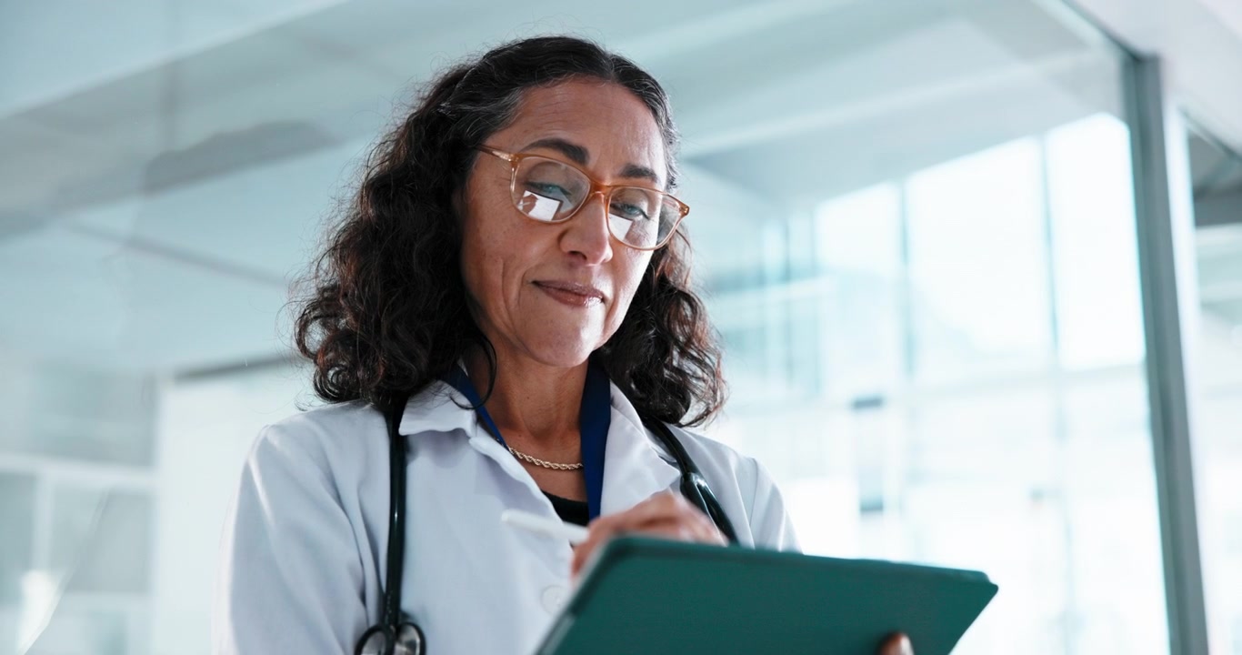 Mature Female Doctor Using Digital Tablet in Hospital