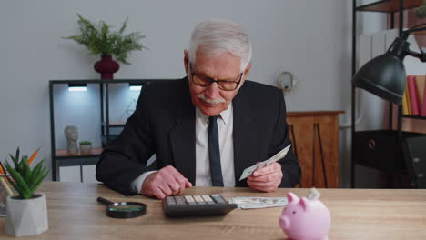 Senior-business-office-man-accountant-or-banker-using-calculator-making-money-cash-calculations