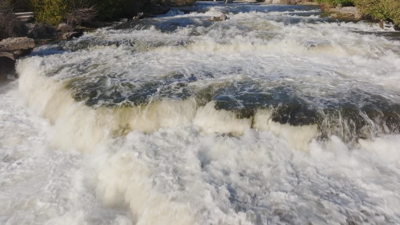 Rushing waterfall in Owen Sound, Canada during daytime with lush greenery around