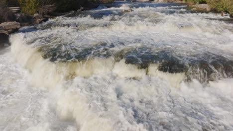 Rushing-waterfall-in-Owen-Sound,-Canada-during-daytime-with-lush-greenery-around