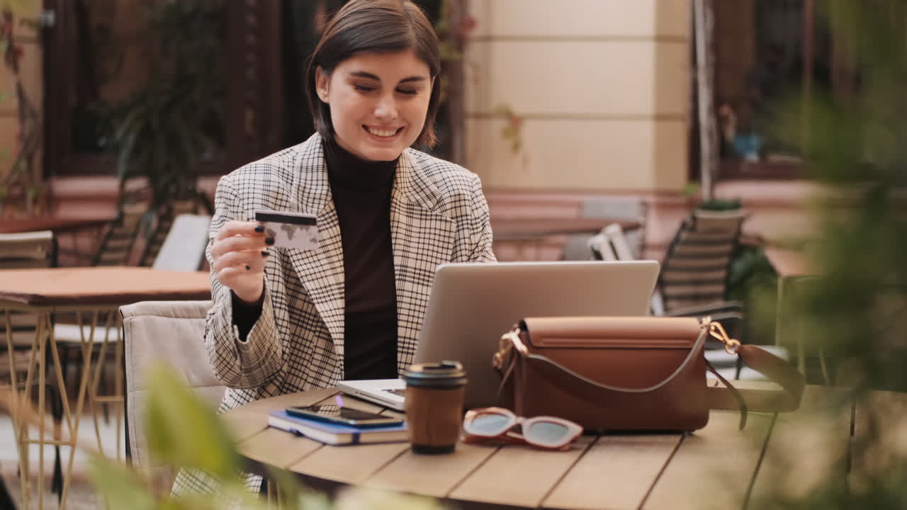 una bella donna sorridente che paga gli acquisti online con carta di credito.