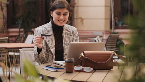 beautiful smiling woman paying for online purchases by credit card.