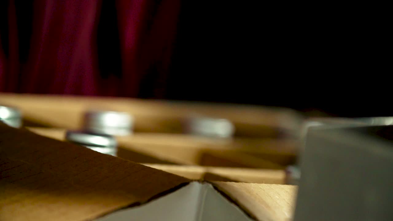 Close-up of a Caucasian hand placing a white wine bottle into a box filled with wine