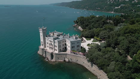 aerial pullback of miramare castle trieste, italy on waters edge