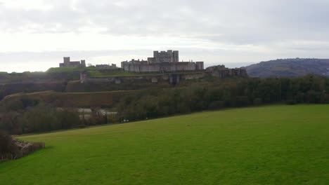 Dolly-forward-drone-shot-over-farm-land-over-Dover-Castle-towards-city-and-port-UK