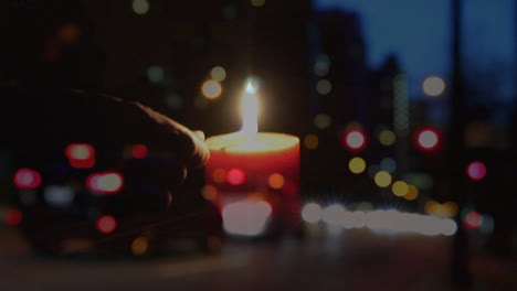 animation of person lighting candle over out of focus city lights