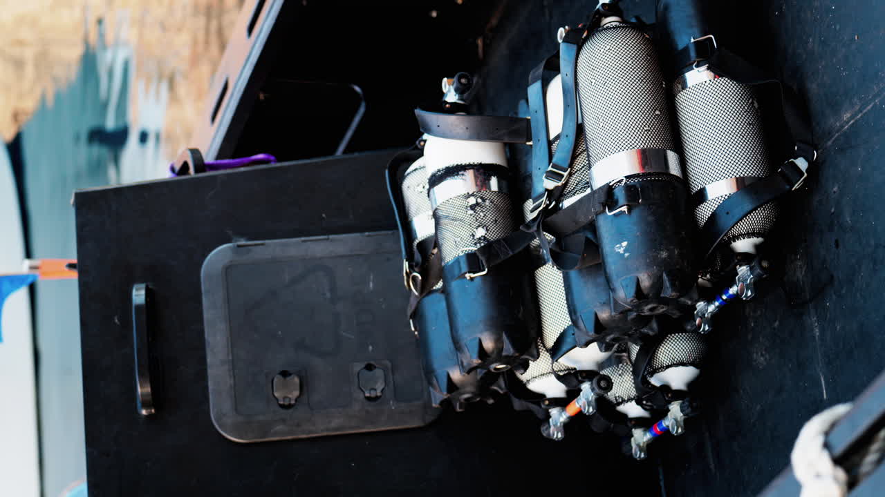 Close up of multiple blue and gray air tanks on a boat. Vertical