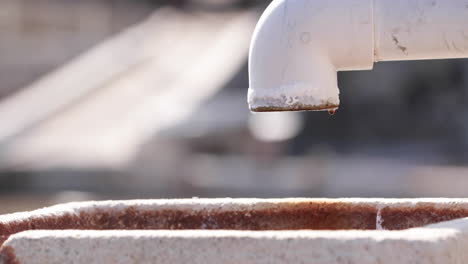 Tubería-De-Plomería-Blanca-Con-Fuga-De-Agua-Goteando-Al-Aire-Libre