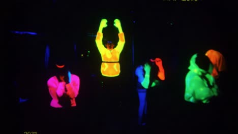 vivid neon expressions: a captivating contrast of emotions in fluorescent glow captured in two frames, showcasing unique stances and color dynamics of participants