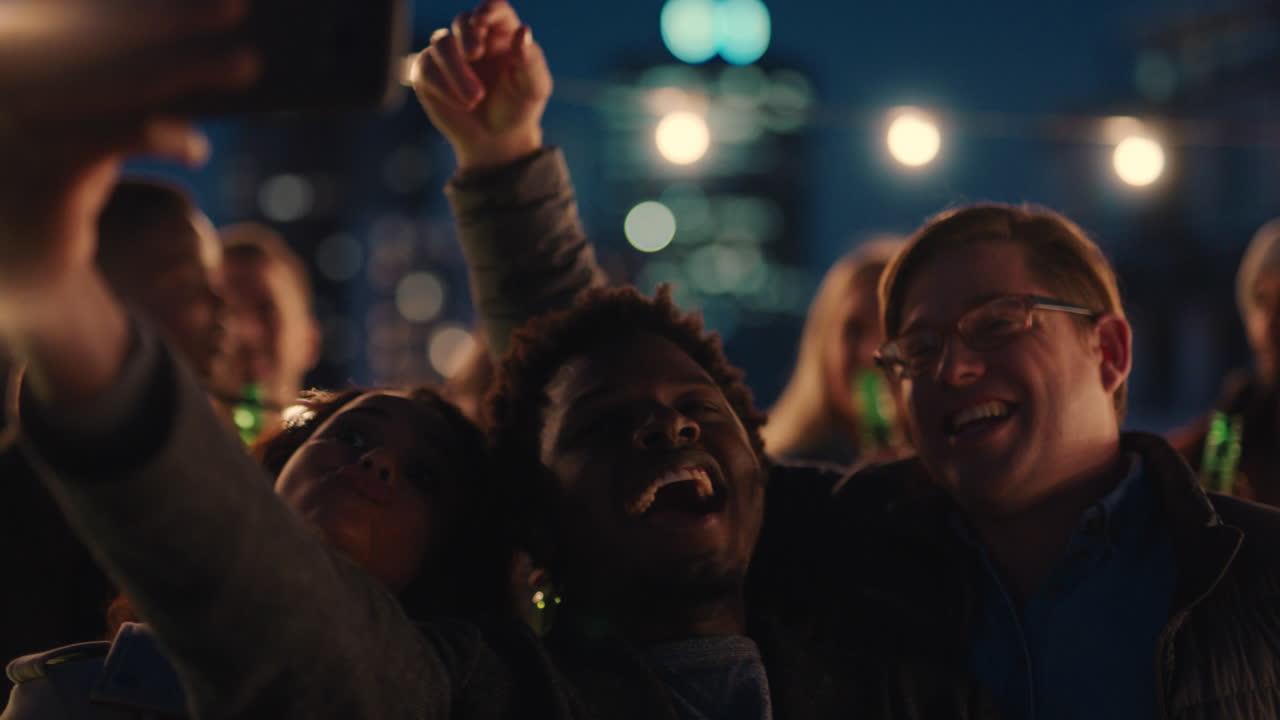 feliz fiesta en la azotea amigos divirtiéndose joven hombre afroamericano tomando fotos usando teléfono inteligente compartiendo el estilo de vida del fin de semana en las redes sociales por la noche
