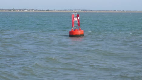 Boya-Roja-De-Navegación-Marina-Flotando-En-La-Entrada-Del-Puerto-De-Dublín-Inclinada-Hacia-Arriba