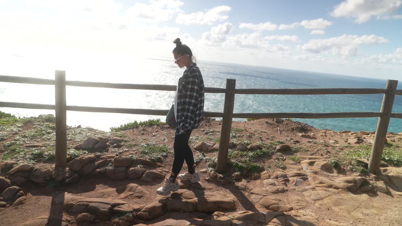 mujer caminando a lo largo del acantilado costero