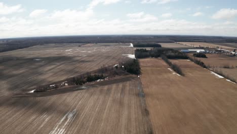 Amplias-Llanuras-Abiertas-Y-Campos-Agrícolas-Vacíos-A-Principios-De-La-Primavera-Con-Charcos-De-Agua-Y-Parches-De-Nieve