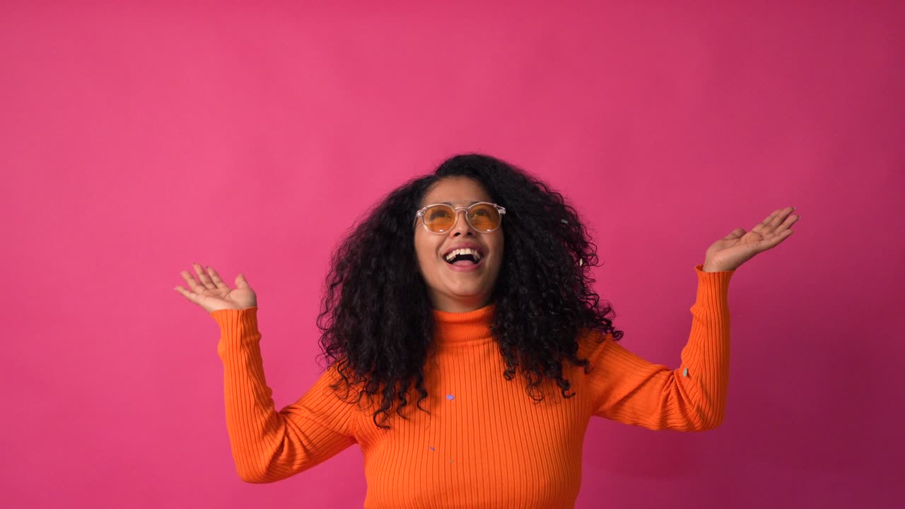 Woman with curly hair throwing confetti