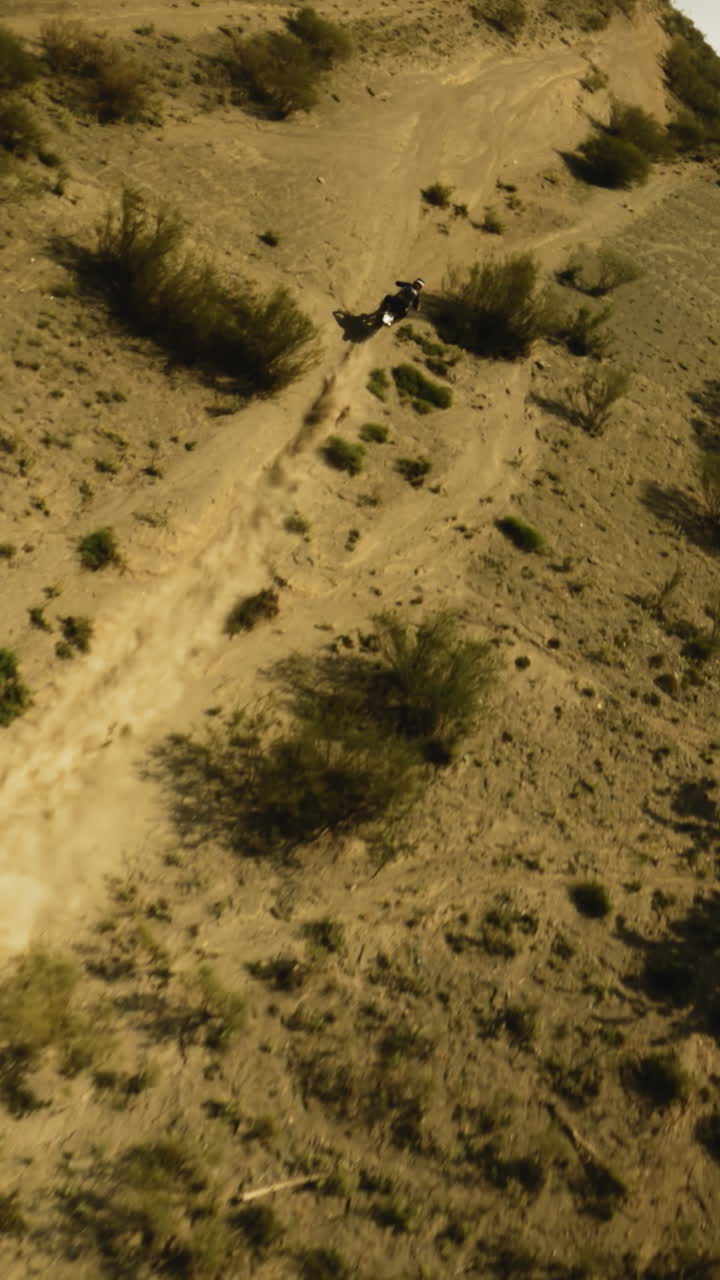 solo motociclista sube la colina polvorienta fpv. piloto maniobras a través de la zona fuera de carretera convirtiéndose en uno con la máquina en las carreras. sentido de libertad y aventura