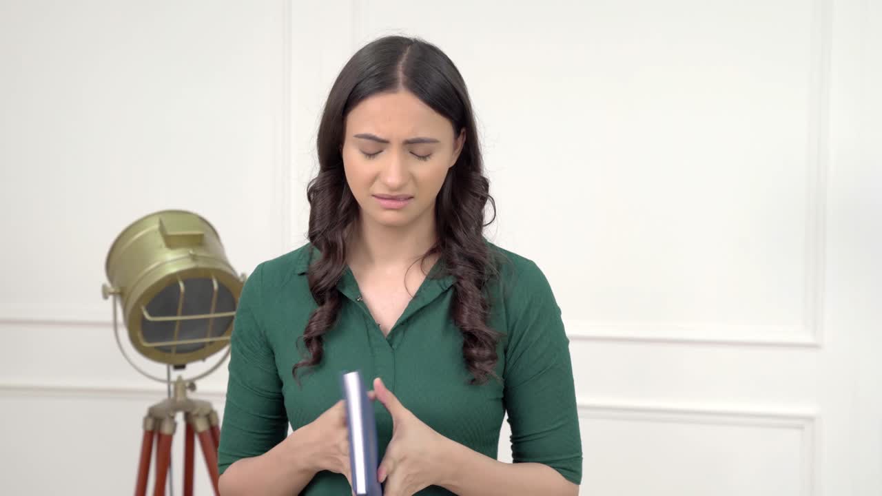 una mujer india frustrada cierra el libro