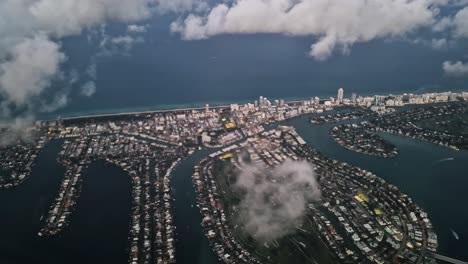 flying above miami beach and clouds, airplane passenger point of view, florida usa