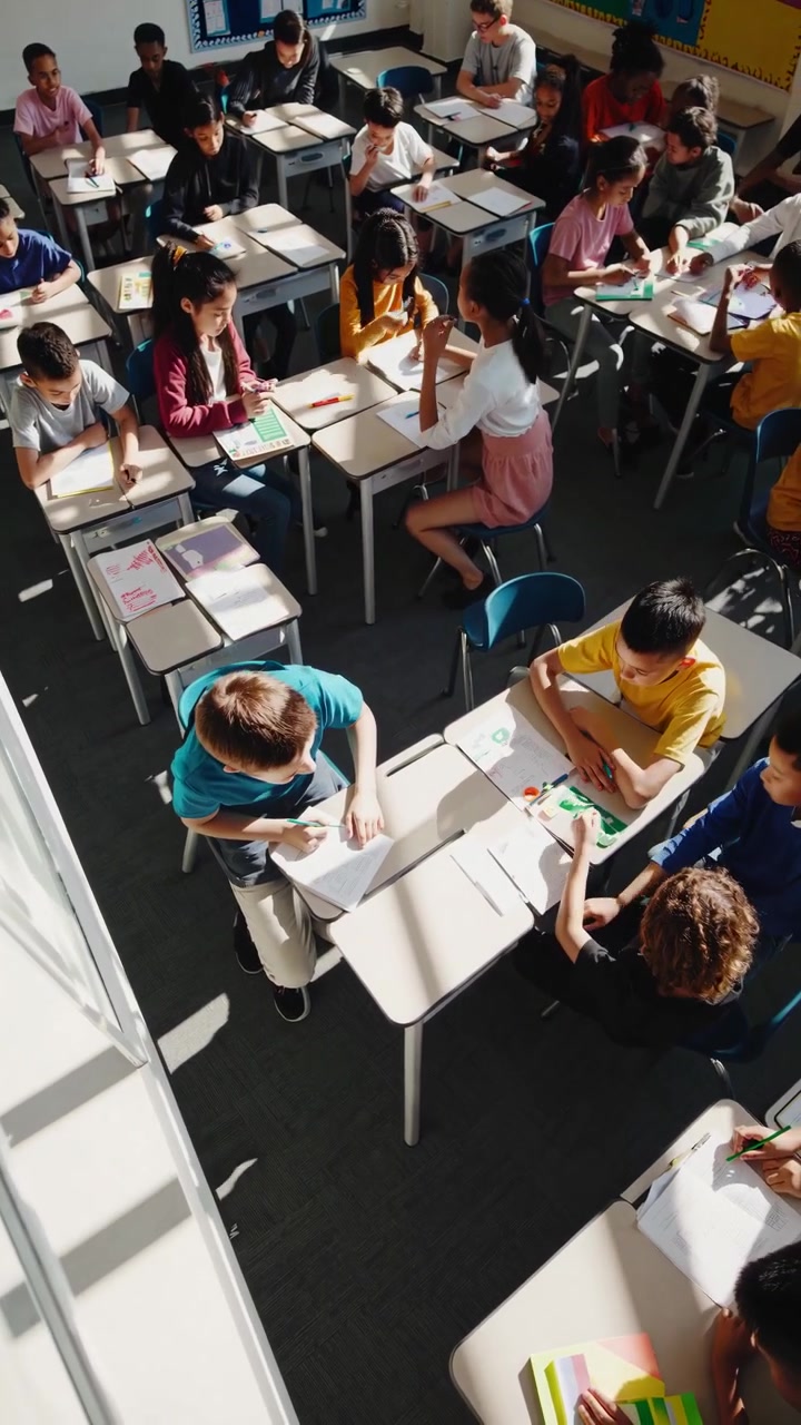 Vista dall'alto di diversi bambini delle scuole elementari che imparano in classe
