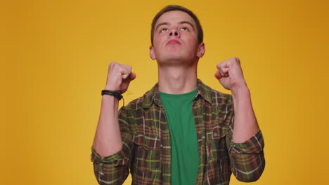 Stylish-man-boy-in-shirt-shouting,-raising-fists-in-gesture-I-did-it,-celebrating-success,-winning