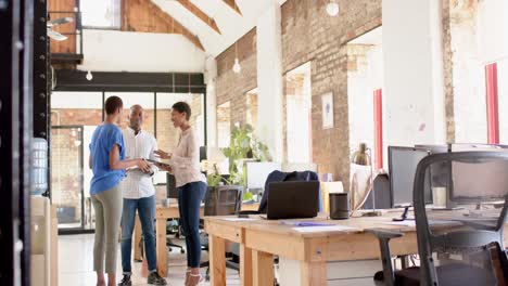 Happy-african-american-colleagues-using-tablet-and-discussing-work-in-office,-slow-motion