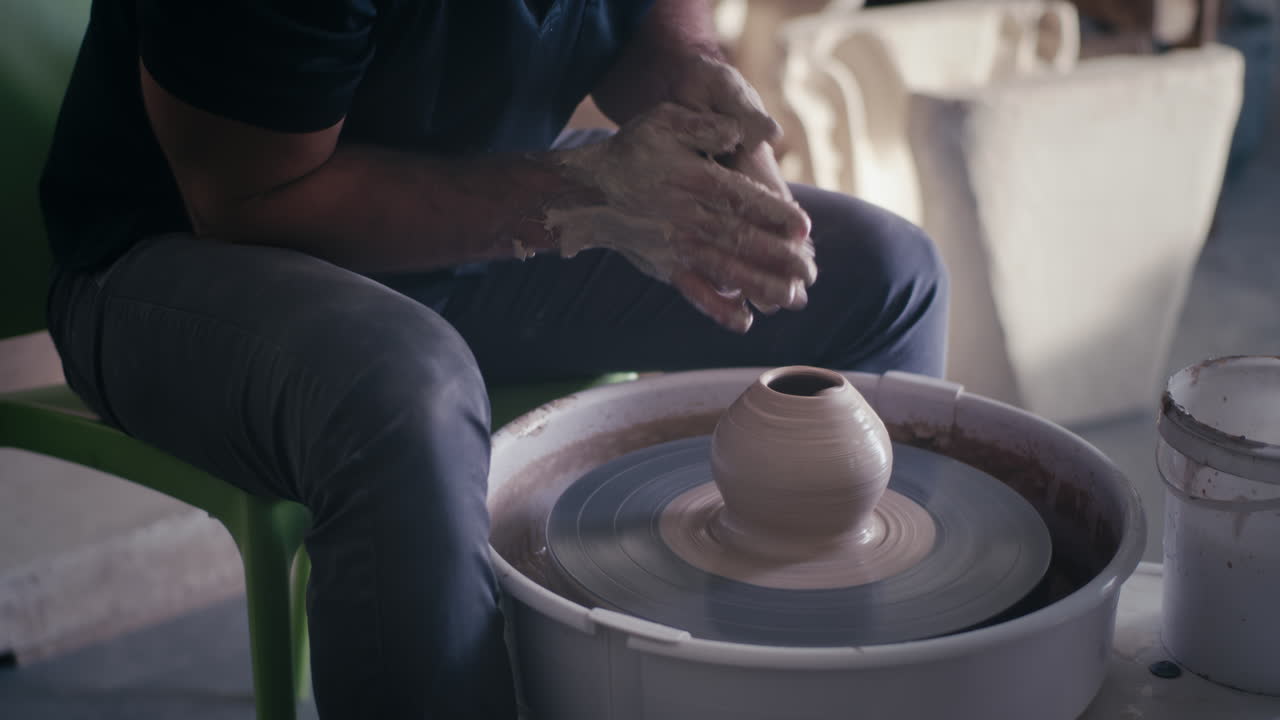 A Potter Shaping Clay on a Pottery Wheel
