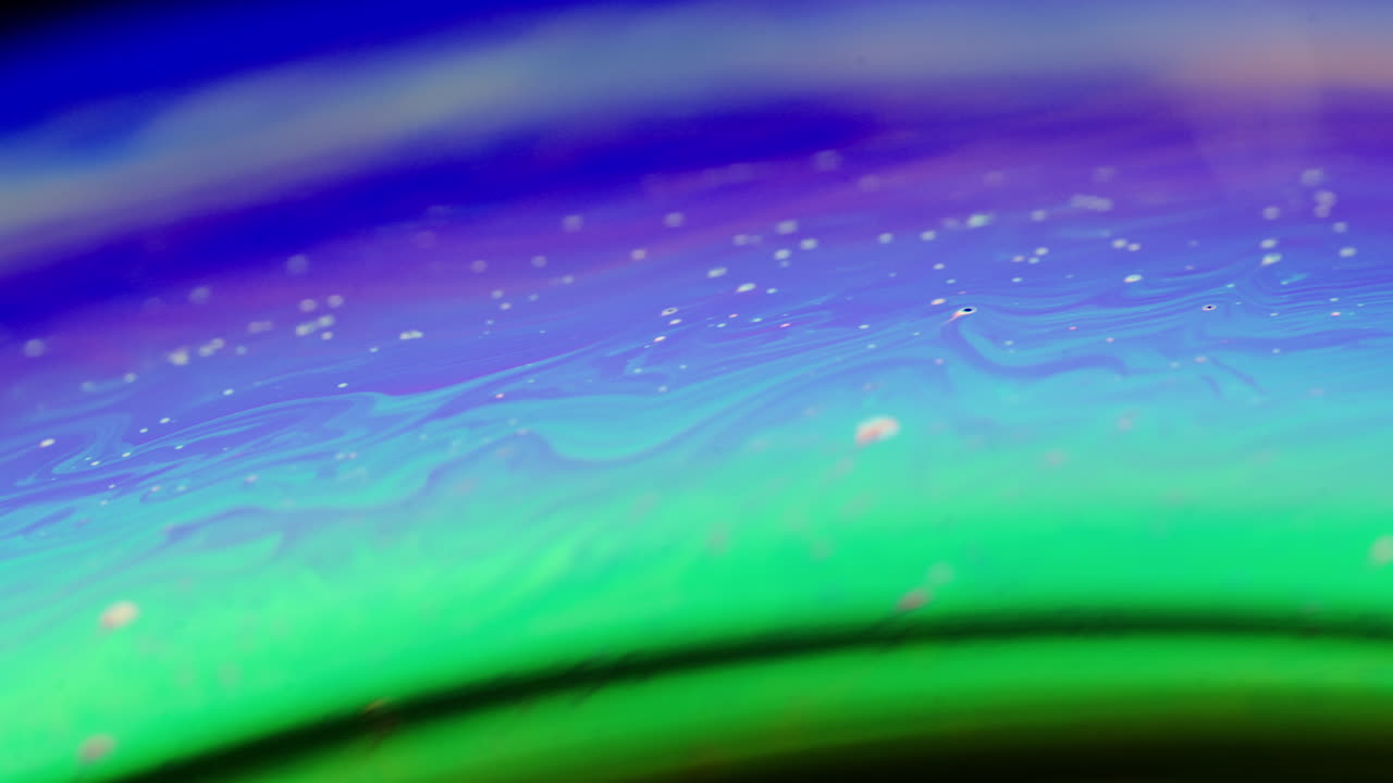 Colorful bubbles forming on a liquid surface, macro shot of mixed liquids