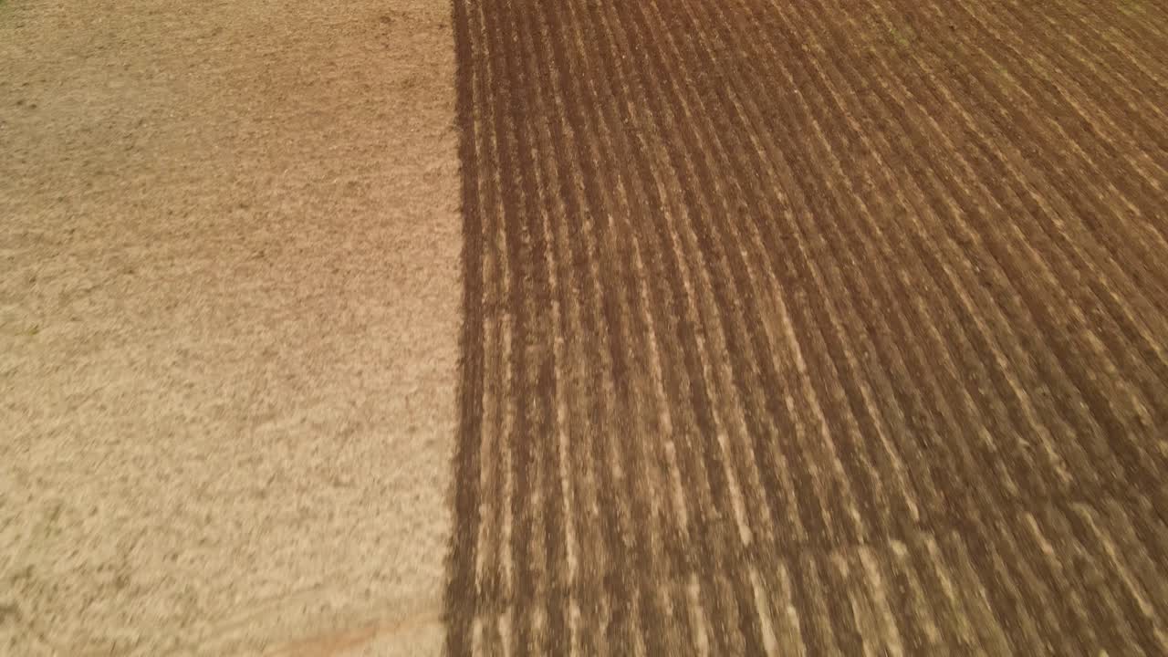 imágenes aéreas que muestran líneas verticales contrastantes de tierras de cultivo recién labradas en un campo remoto en el sudeste asiático