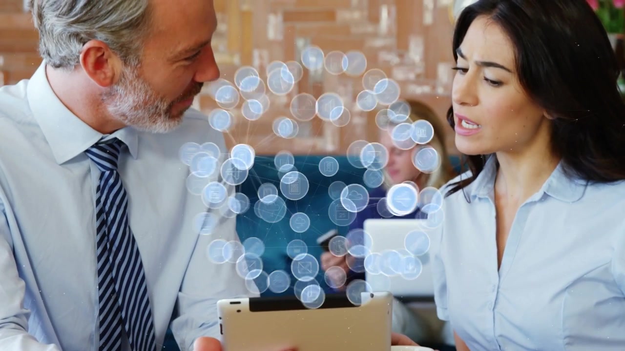 Video verticale: un team in abiti da lavoro in un caffè tiene un tablet, guarda apparire icone e parla di lavoro.