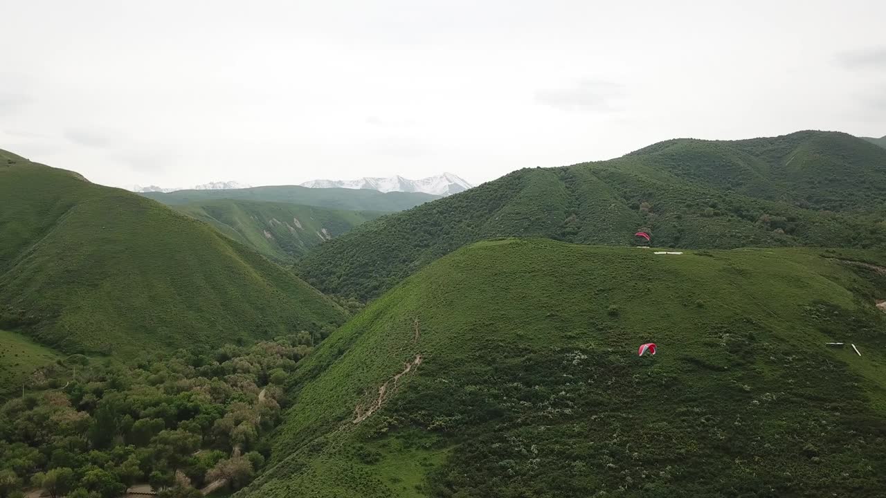 parapenteo en las montañas, campos verdes, colinas