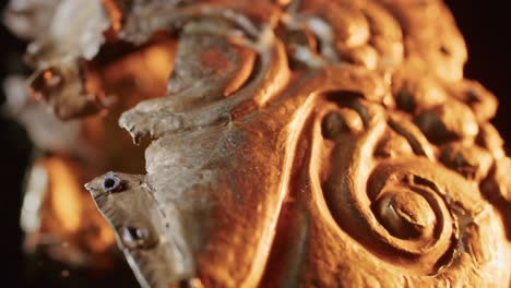 a gold brooch of a scythian priestess 2000 years old, an old earring, a spinning wheel, found during excavations. vintage jewelry. religion. close-up