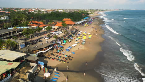 panoramic drone shot of overcrowded batu bolong beach, canggu, indonesia