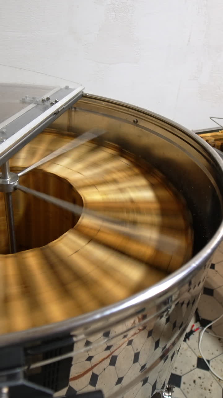 Honey frames rotating in centrifuge. Organic fresh sweet honey harvesting. Vertical video